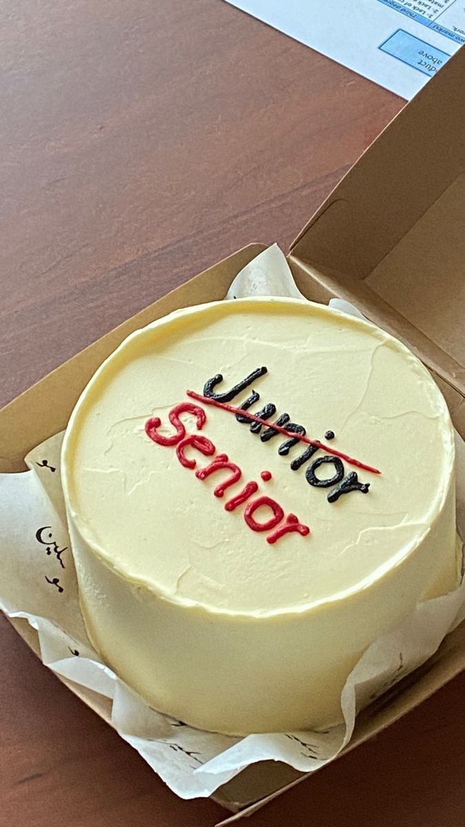 a white cake in a box with the words junior simon on it's side