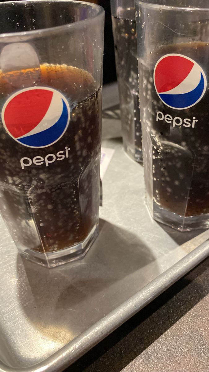 two glasses with pepsi on them sitting on a tray