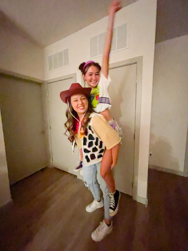 two girls are standing in an empty room and one is wearing a cowgirl costume