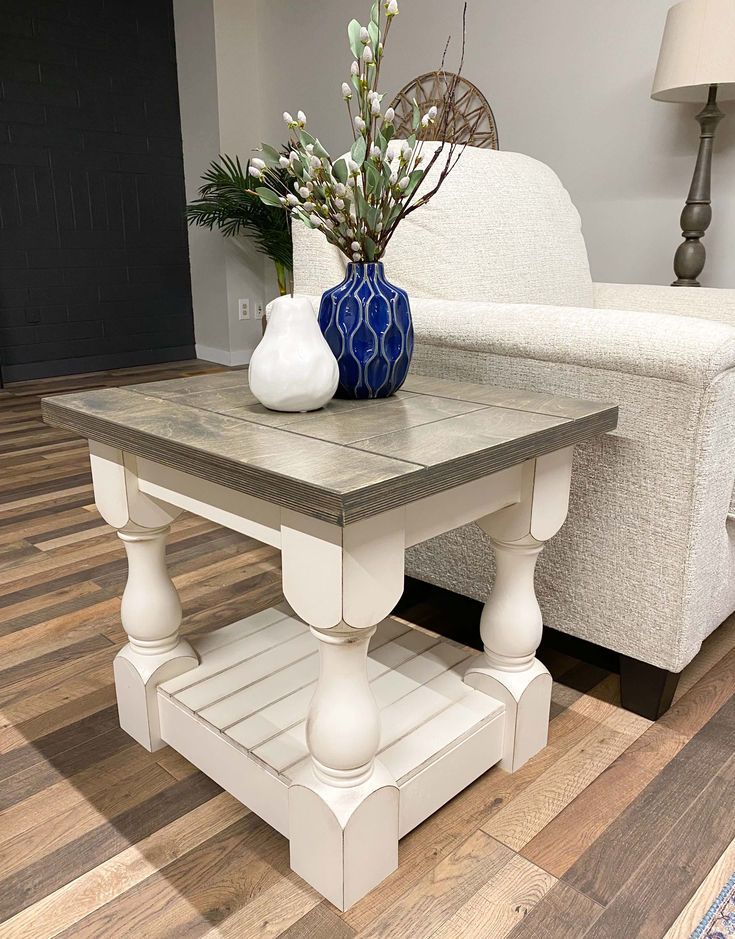 a white couch sitting next to a table on top of a hard wood floor in a living room