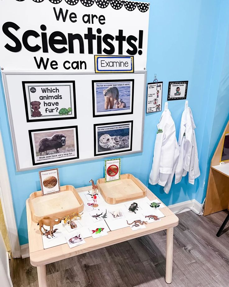 a table with some pictures on it in front of a sign that says we are scientist's