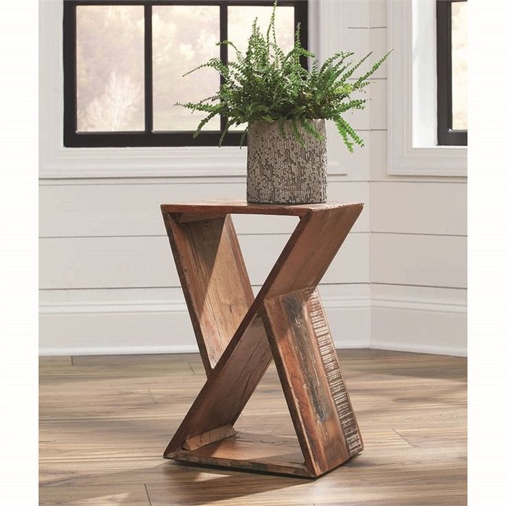 a potted plant sitting on top of a wooden table in front of a window