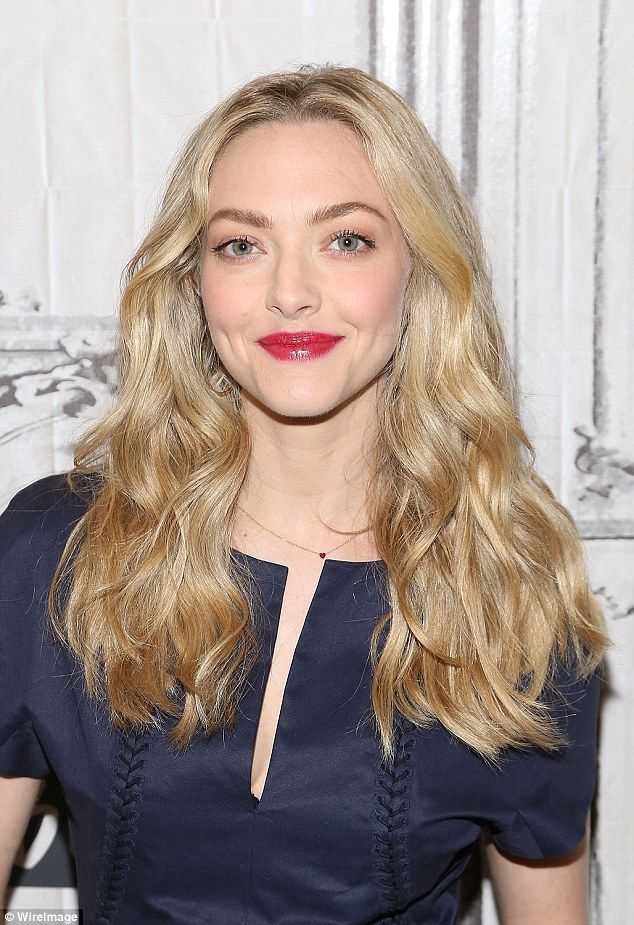 a woman with long blonde hair wearing a blue dress and red lipstick is posing for the camera