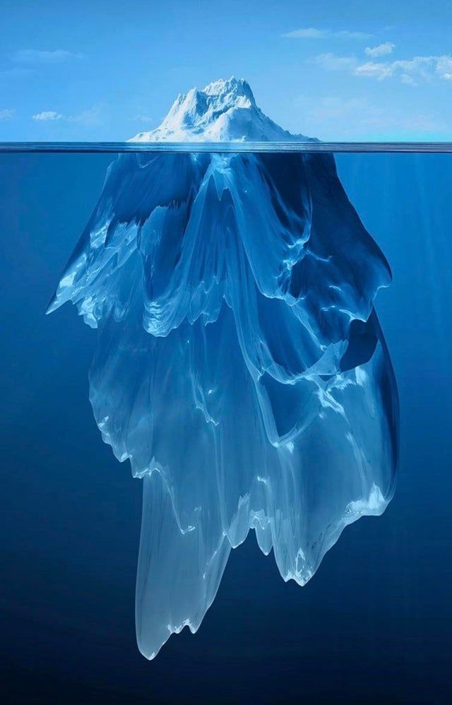 an iceberg floating in the middle of the ocean