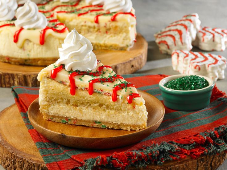 two slices of cheesecake with whipped cream and peppermint toppings on wooden platters