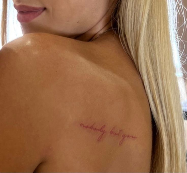 the back of a woman's shoulder with writing on it