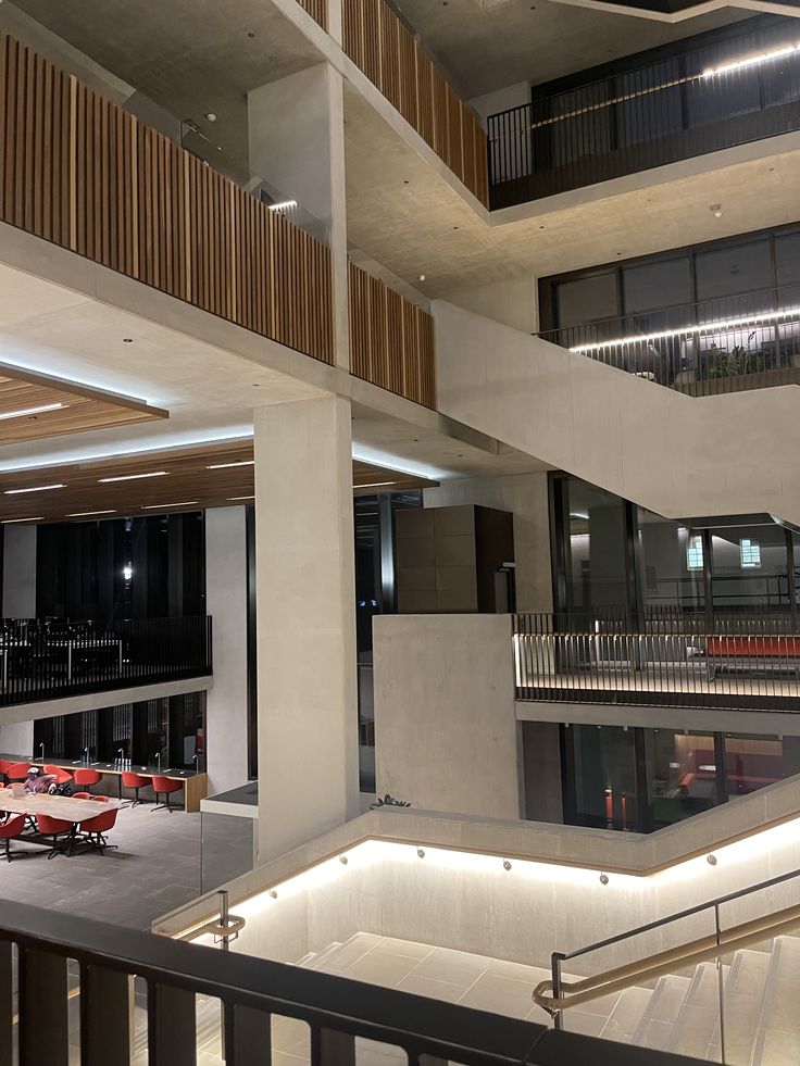 the interior of an office building with tables and red chairs in front of it,