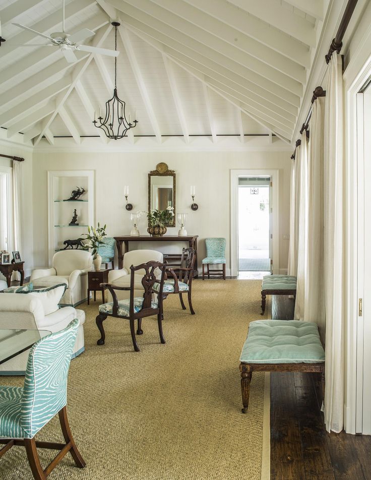 a living room filled with furniture and a chandelier hanging from the ceiling next to a doorway