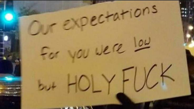 a person holding a sign that says our expectations for you are low by holyfuck