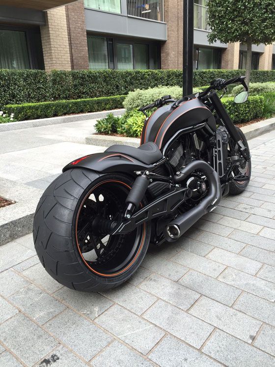 a black motorcycle parked on top of a sidewalk