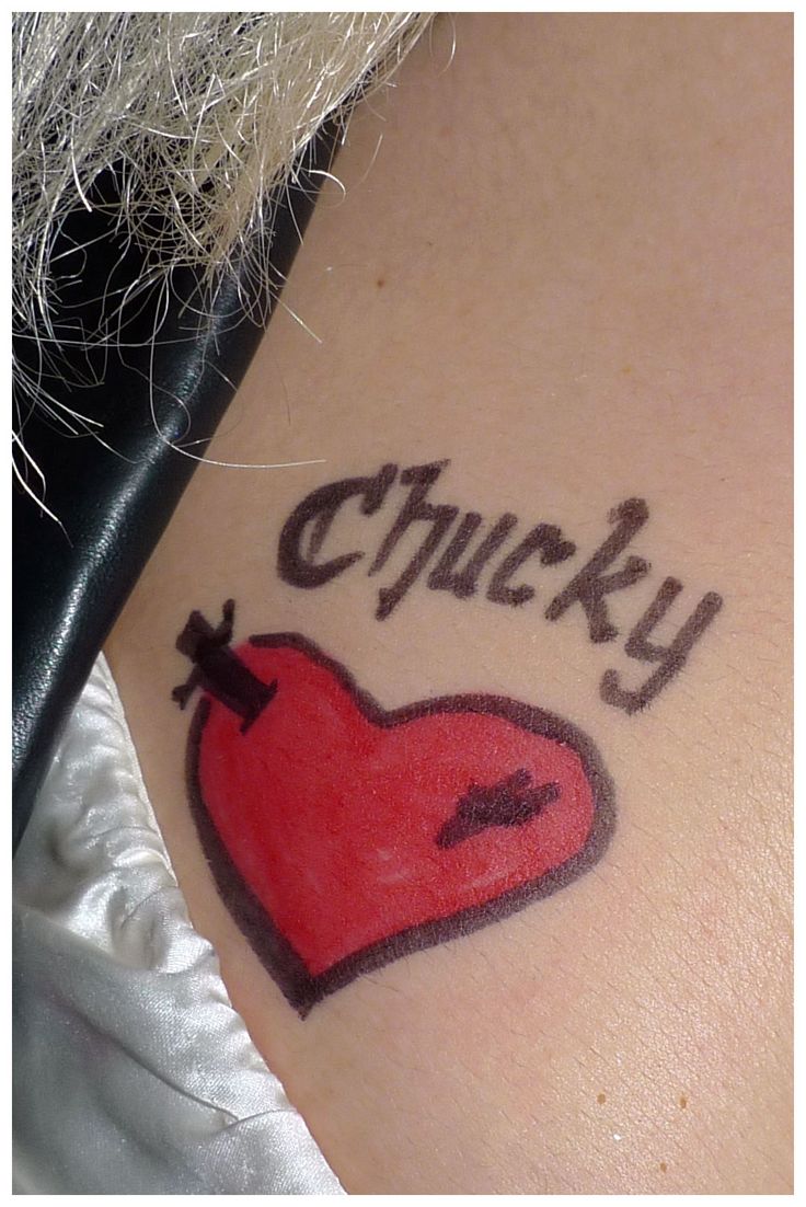 a tattoo with the word chucky written on it and a heart in the middle