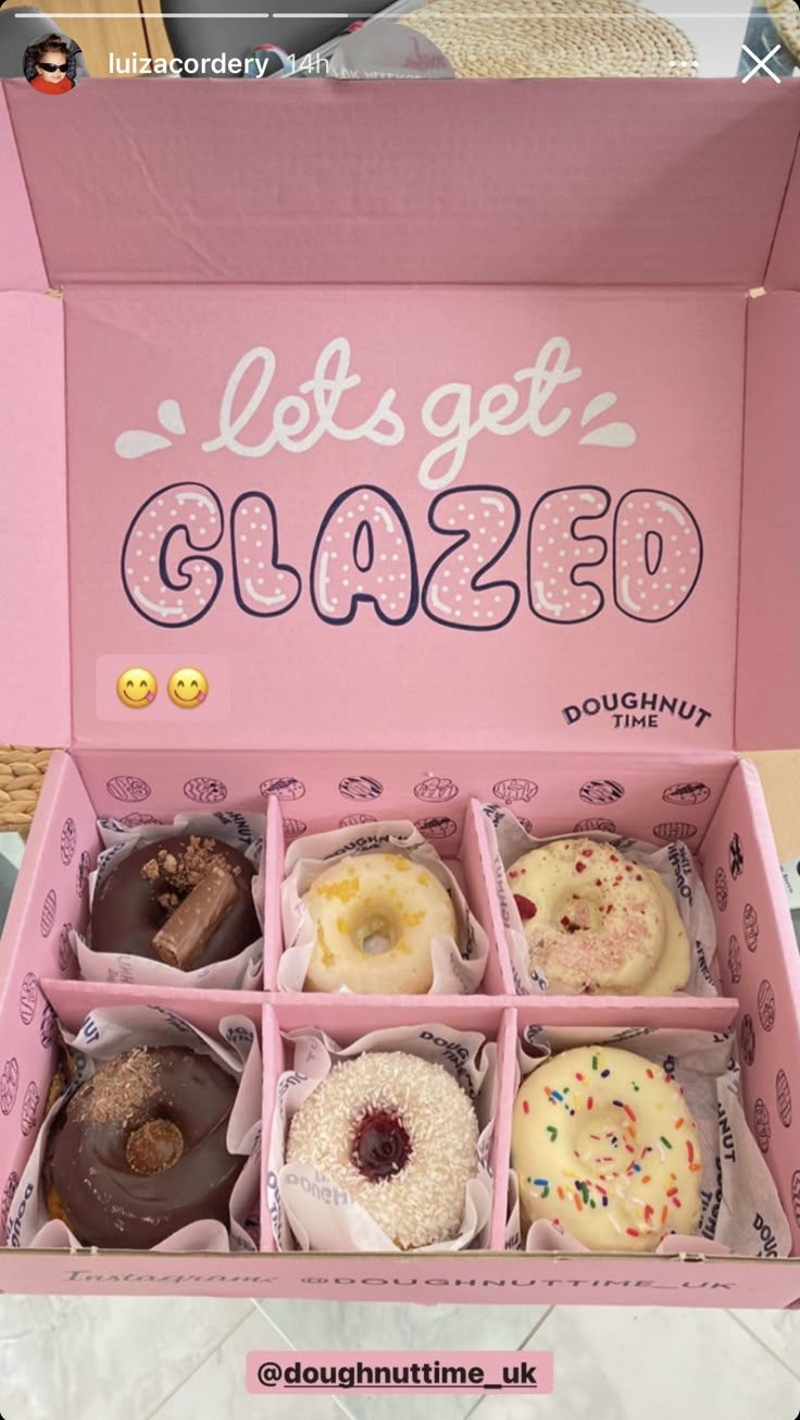 a pink box filled with lots of donuts