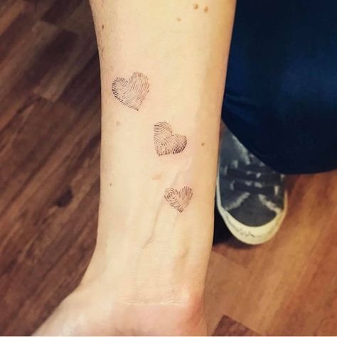 a woman's arm with three hearts on it