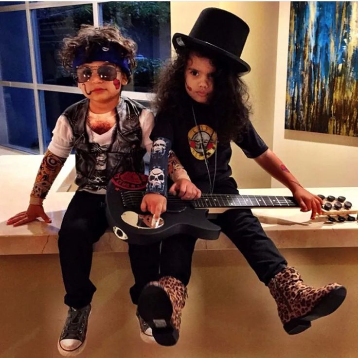 two children sitting on a window sill with guitars in their hands and one holding a guitar