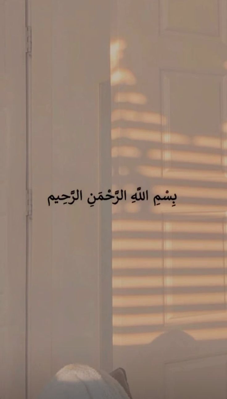 the shadow of a window on a wall with arabic writing in black and white colors