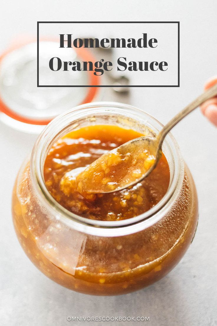 a person holding a spoon in a jar filled with food