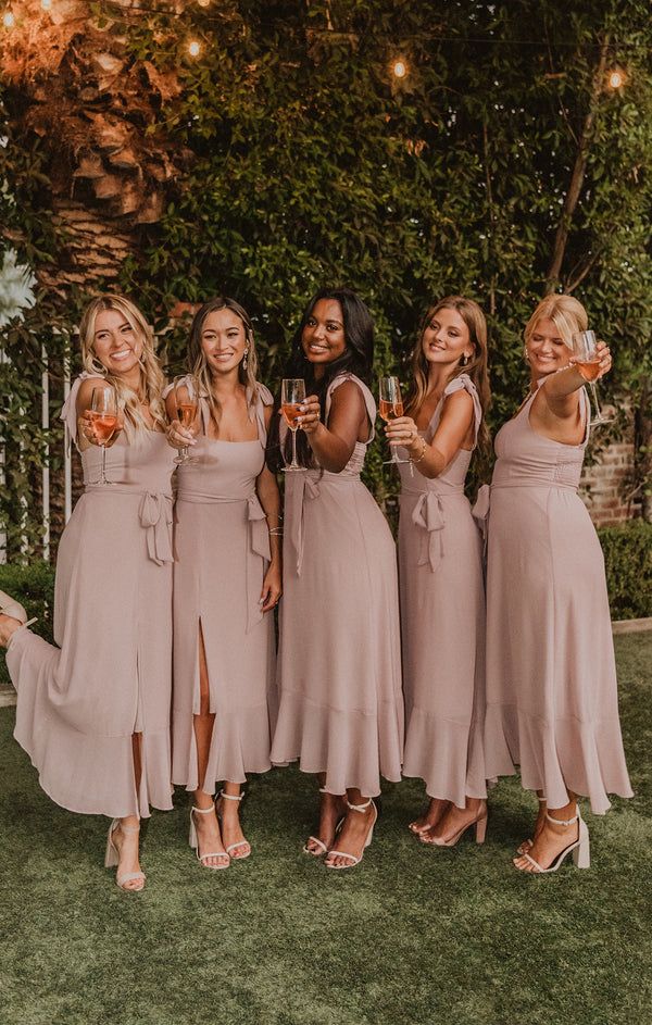 the bridesmaids are all wearing pink dresses and holding champagne glasses in their hands