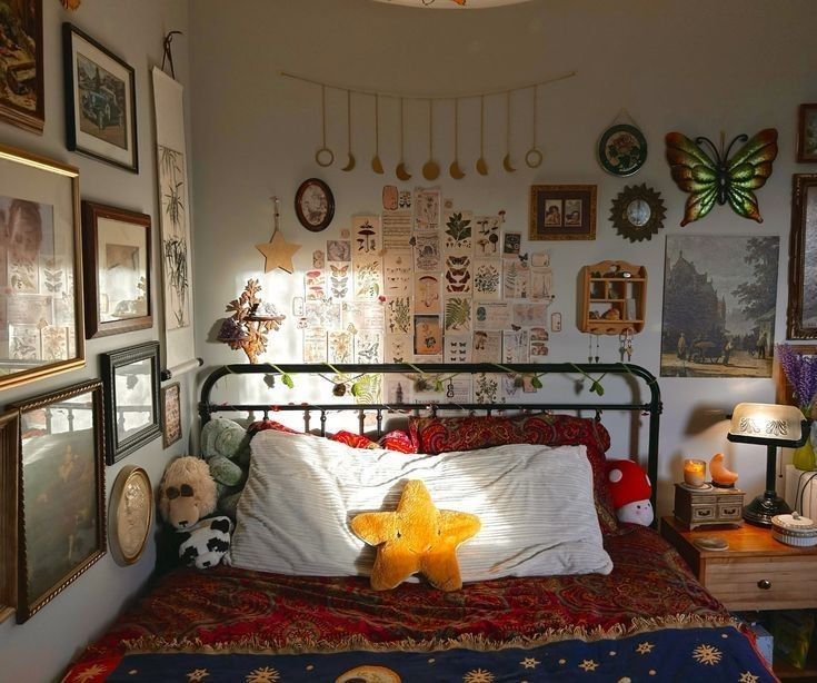 a bedroom with many pictures on the wall and a teddy bear laying on the bed