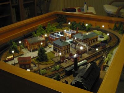 a model train set is shown in a wooden box with its lights on and the tracks lit up