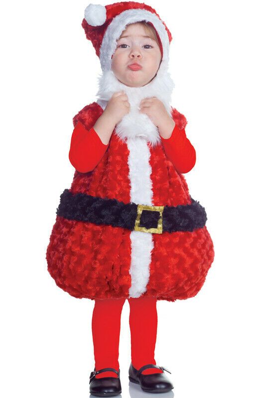 a little boy dressed as santa clause standing in front of a white background with his hand on his mouth