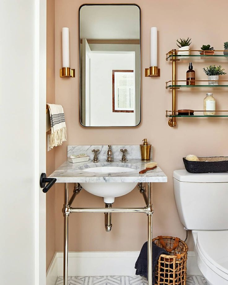 a bathroom with pink walls and gold fixtures