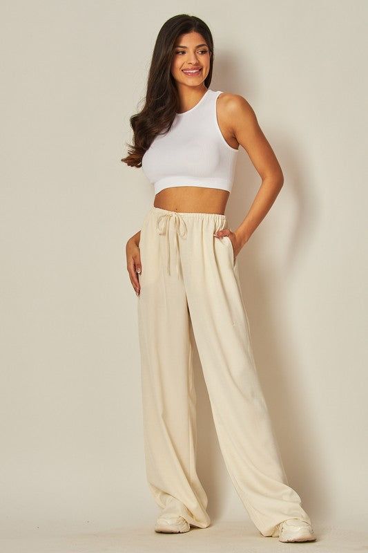 Model is wearing Ivory Satin Wide Leg Pants  and white top and sneakers Satin Wide Leg Pants, Upgrade Your Look, Pants Large, Leg Design, Chic Fashion, Fashion Essentials, Leg Pants, Wide Leg Pants, Chic Style