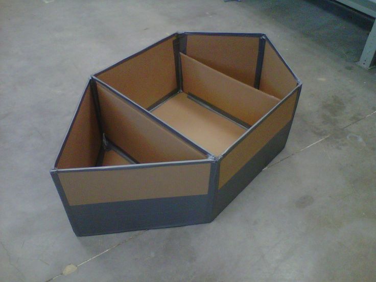 an open cardboard box sitting on the floor in a room with concrete floors and walls