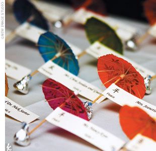 several colorful umbrellas with name tags attached to them sitting on top of a table