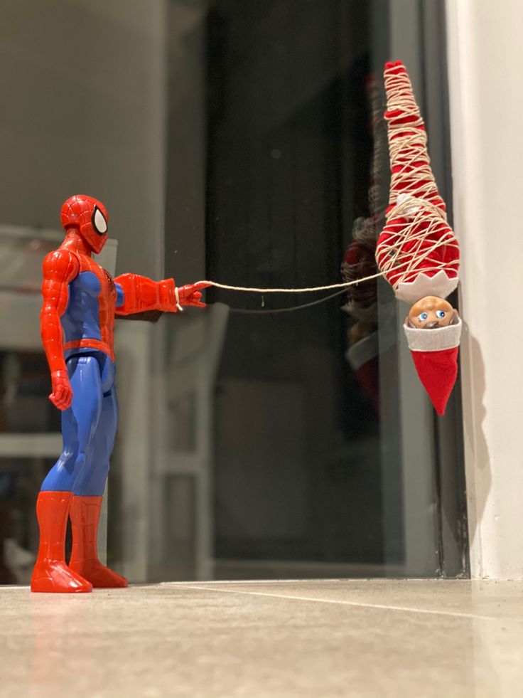 a toy spider - man is trying to pull another toy