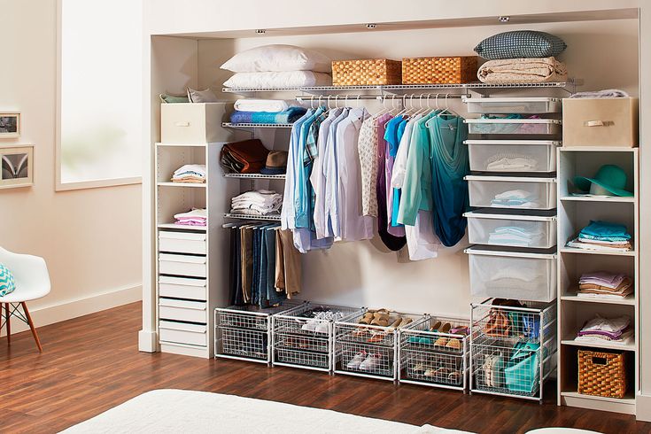 an organized closet with clothes, shoes and other items on shelves next to a bed