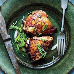 two pieces of chicken on a plate with a fork and knife