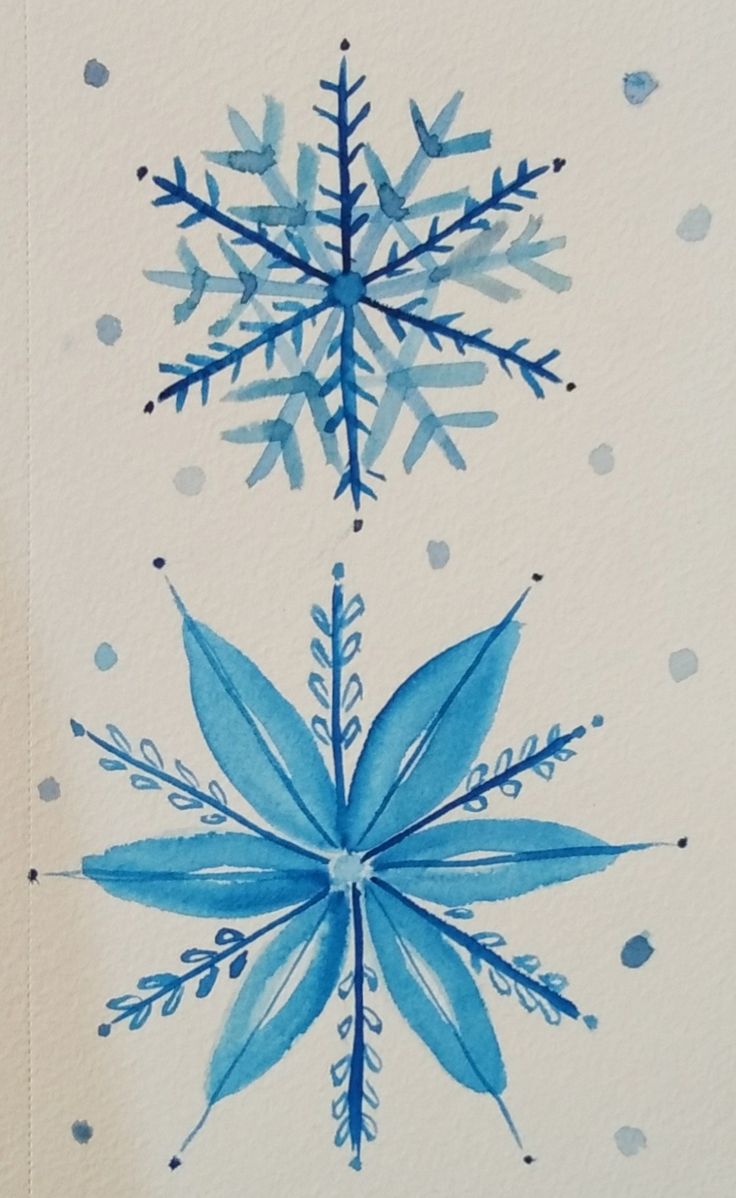 a drawing of a snowflake on a white paper with blue dots around it