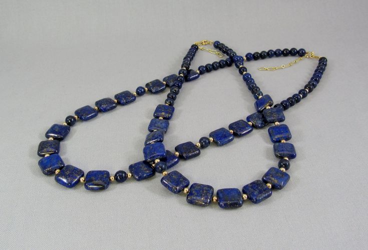 "Uniquely cut square \"pillows\" of vibrant blue lapis lazuli spaced with 14K gold filled beads create this beautiful adjustable length necklace. Two sizes are available, each with a 2 inch gold filled chain so every woman can get their best fit. The 12 mm squares are large enough to showcase the beauty of the natural stone, yet small enough for an everyday fashion accessory. Choose from 16 to 18 inch and 20 to 22 inch, that's 41-46 cm or 51-56 cm for my non-US visitors. Or send me a message to Rectangular Gemstone Beads Gold Jewelry, Gold Rectangular Gemstone Beads Jewelry, Blue Beaded Rectangular Jewelry, Gold Rectangular Jewelry With Gemstone Beads, Rectangular Gold Jewelry With Gemstone Beads, Blue Rectangular Beaded Jewelry, Elegant Rectangular Polished Beads Jewelry, Rectangular Blue Necklace With Natural Stones, Blue Rectangular Jewelry With Natural Stones