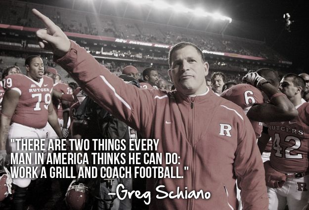 a man in a red jacket standing on top of a football field