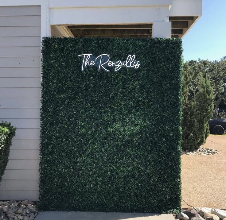 there is a sign that says the regollies on top of some bushes in front of a building