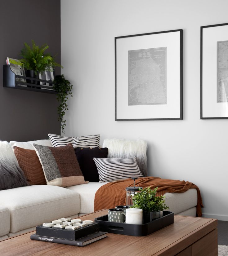 a living room with two pictures on the wall and a coffee table in front of it