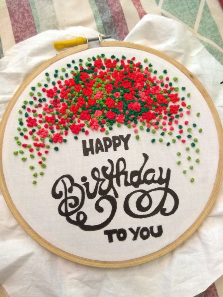 a happy birthday to you embroidered on a piece of white paper with red and green sprinkles