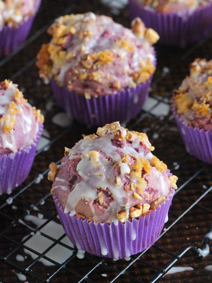 purple cupcakes with white frosting on a cooling rack and the words, naturally purple ube muffins