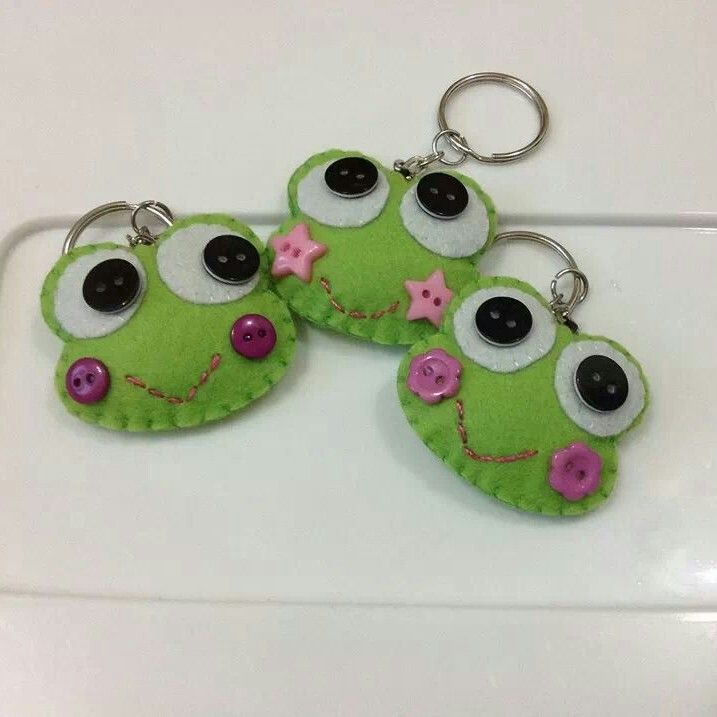 three green keychains with eyes and stars on them sitting on a white surface