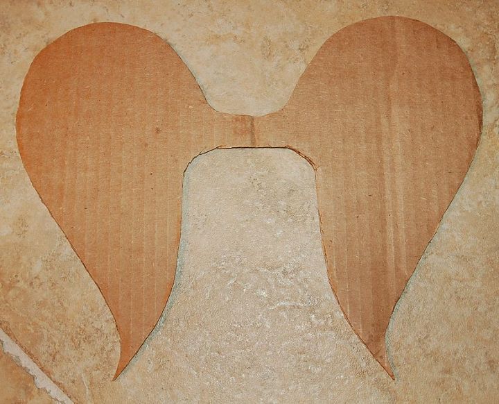 two hearts cut out of cardboard sitting on the ground