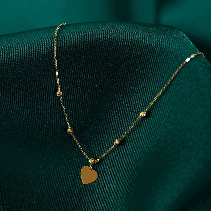 Introducing our stunning 14k Gold Beaded Heart Necklace, a timeless piece that oozes elegance and charm. Handcrafted with utmost care, this dainty necklace features delicate beads intricately arranged to form a captivating heart pendant. The use of high-quality 14k gold adds a touch of opulence and sophistication to this accessory, making it perfect for special occasions or daily wear. Whether you are looking to treat yourself or searching for a thoughtful gift, this necklace is sure to make hea Elegant Gold Necklaces With Heart Beads, Elegant Heart Necklace With Delicate Chain, Elegant Rose Gold Jewelry With Heart Beads, Delicate Chain Heart Necklace In 14k Gold Filled, Elegant Heart Necklace With Delicate Chain As A Gift, Dainty Pendant Necklace With Beaded Chain, Elegant Round Bead Necklaces As A Gift For Her, Elegant 14k Gold Filled Heart Pendant Jewelry, Elegant Necklace With Round Beads As Gift For Her