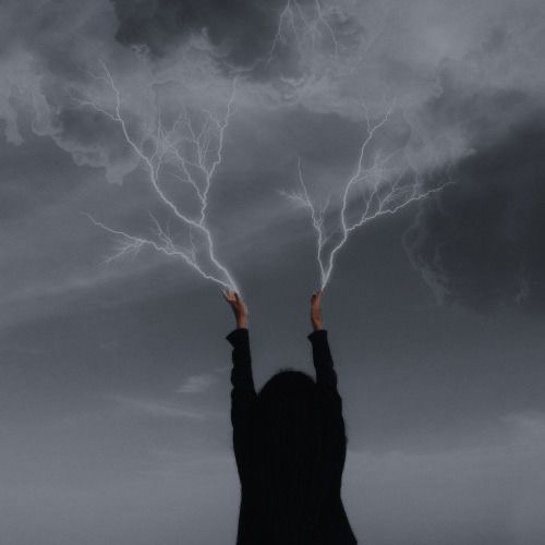 a woman is holding her hands up in the air with two lightning bolts above her head