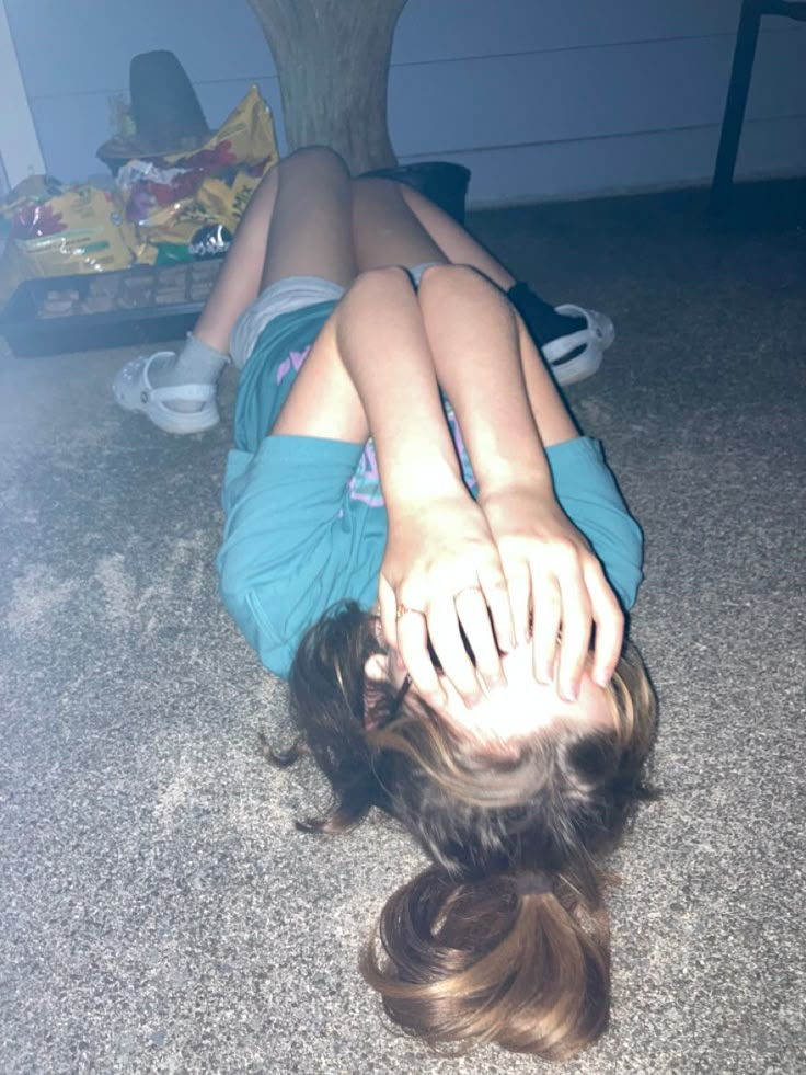 a person laying on the floor with their head down and hands up in the air