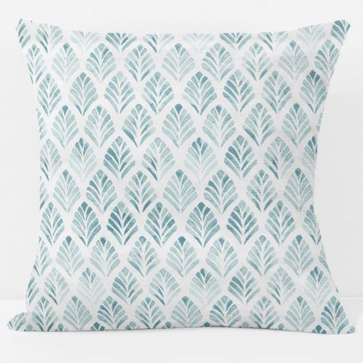 a blue and white pillow with leaves on it