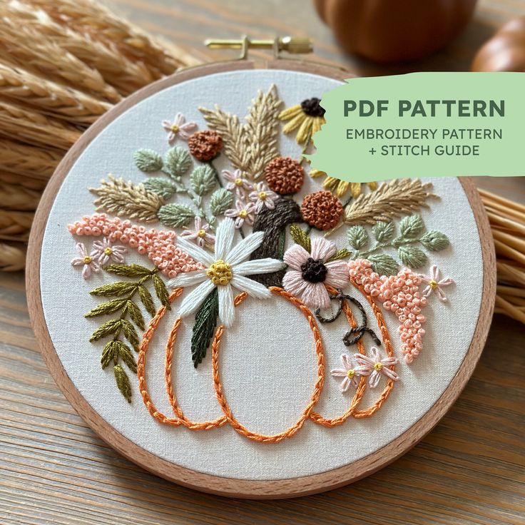 the embroidery pattern is being displayed in front of some pumpkins and other autumn decorations