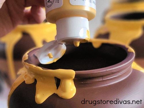 a person is pouring yellow liquid into a jar