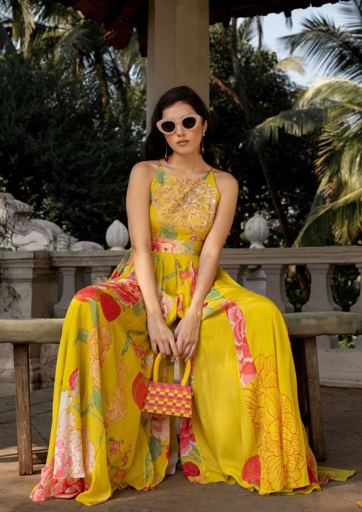 The lime yellow big floral jumpsuit is perfect for destination wedding celebrations, details of dramatic, flowy and easy breezy silhouette makes the fit more chic and classic, the bodice is hand highlighted on digitally printed flowers using tone to tone sequins, moti, mirror and cutdana. It is styled with same printed belt to accentuate the waist. Summer Party Sets With Printed Motifs, Elegant Floral Print Palazzo Set For Party, Yellow Palazzo Set With Printed Motifs For Wedding, Wedding Yellow Palazzo Set With Printed Motifs, Summer Floral Print Palazzo Set For Parties, Summer Party Palazzo Set With Floral Print, Festive Maxi Length Jumpsuits And Rompers, Floor-length Printed Palazzo Set For Party, Floor-length Palazzo Set With Printed Motifs For Party