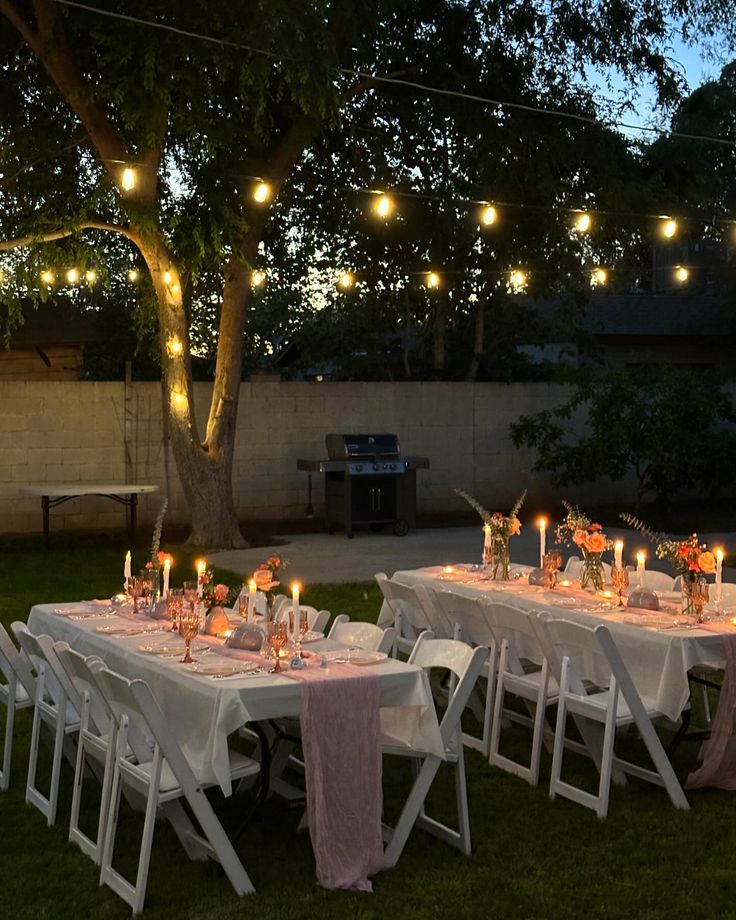 an outdoor dinner table set up with lit candles