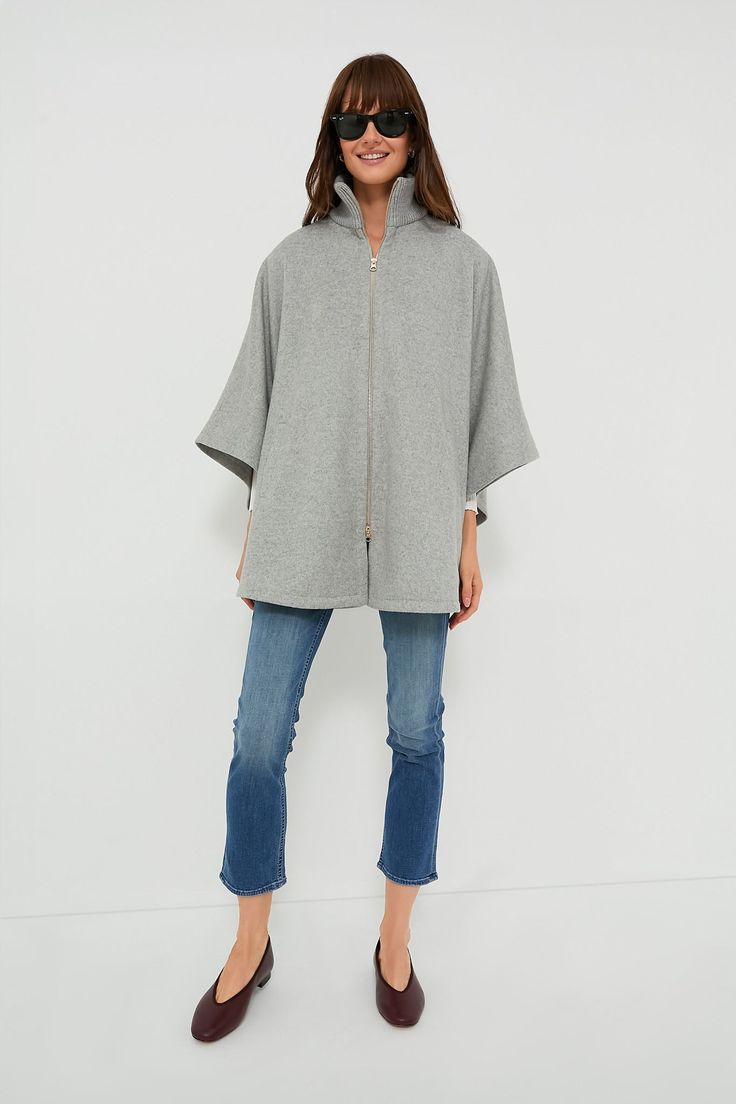 The Grey Full Zip Huntington Cape is a closet must-have for the cold-weather months. The oversized silhouette makes this the perfect layering piece, and the zip closure allows this to be worn on its own or over a button-down. With a wool blend, you are sure to be comfy and cozy in this stylish look- pair with denim and loafers or with a dress and boots for an absolutely elegant outfit. Ribbed stand collar Long poncho sleeves Tonal button at inside of sleeve Gold-tone front zip closure Cape silho Wool Funnel Neck Outerwear For Work, Wool Outerwear With Funnel Neck For Work, Funnel Neck Wool Outerwear For Work, Oversized Funnel Neck Outerwear For Cold Weather, Wool Outerwear With Funnel Neck For Fall, Wool Cape For Cold Weather In Fall, Cashmere Cape For Winter, Fall Wool Cape For Cold Weather, Oversized Funnel Neck Outerwear For Winter