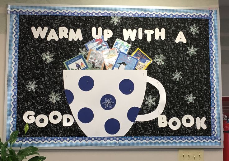 a bulletin board with a blue and white polka dot coffee cup on it that says warm up with a good book